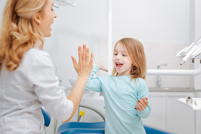 Meisje geeft op jonge leeftijd een high five aan de tandarts