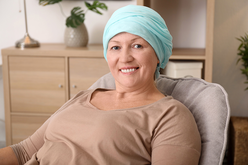 Vrouw lacht naar de camera en heeft mondverzorging bij chemotherapie